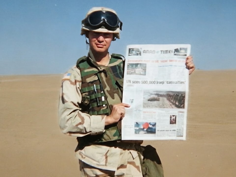 David F. Zapata holding a newspaper in the desert